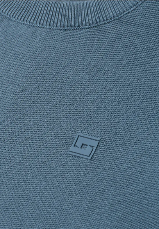 Blaues Strickoberteil mit rundem Rippenkragen und kleinem quadratischem Logo auf der Brust.