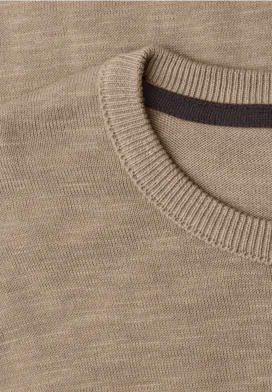 Nahaufnahme eines beigen Strickpullovers mit Rundhalsausschnitt und gerippter Kante