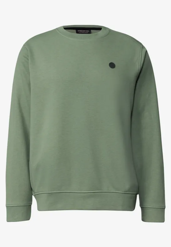 Sweat vert avec un logo rond sur la poitrine.