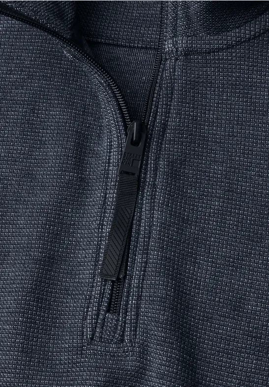 Nahaufnahme eines dunkelgrauen Pullovers mit Reißverschluss und feiner Struktur.