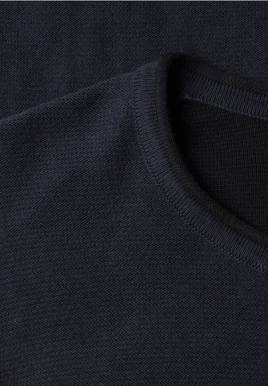 Dunkler, gerippter Rundhalsausschnitt eines Strickpullovers.