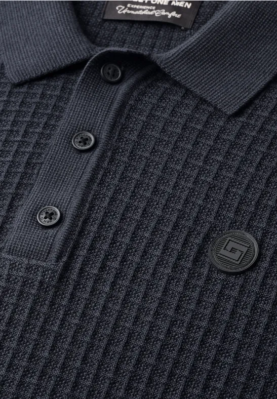 Dunkelgraues Polohemd mit Waffelstruktur, drei schwarzen Knöpfen und rundem Logo-Patch.