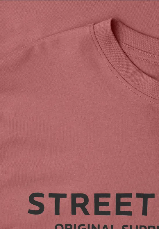 Ein rosa T-Shirt mit schwarzem Aufdruck 'STREET'.