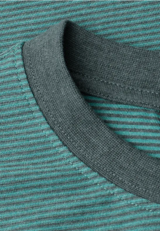 Nahaufnahme eines gestreiften grünen T-Shirts mit rundem Kragen.