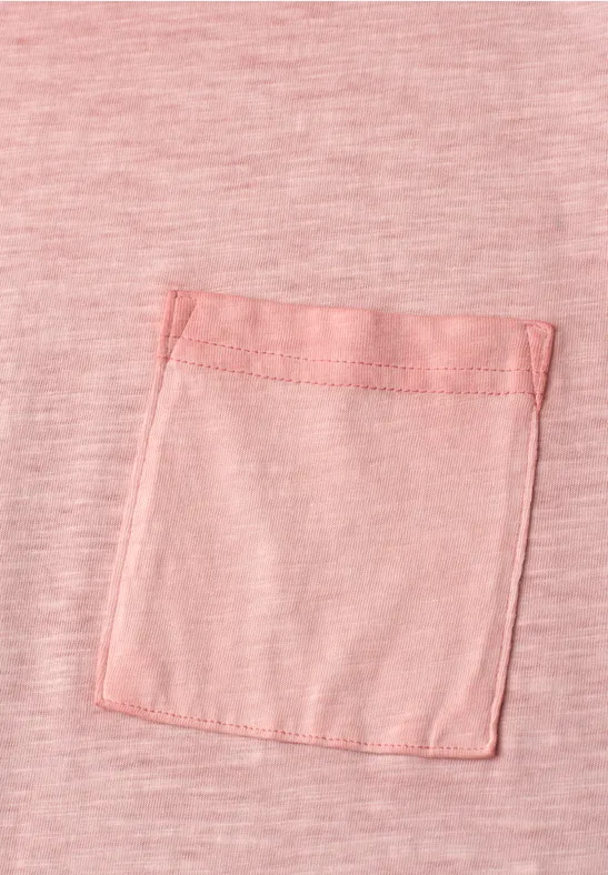 Roze T-shirt met een klein, vierkant borstzakje van dezelfde stof.
