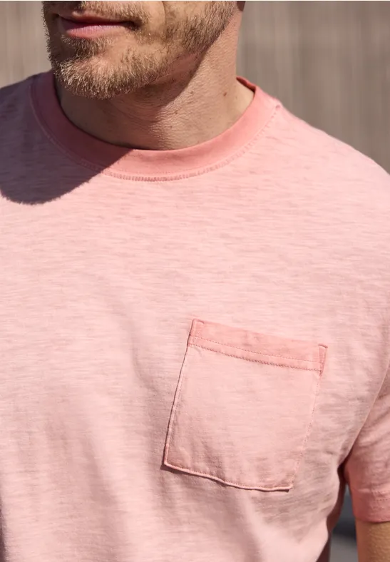 Close-up van een man met een roze T-shirt en borstzakje