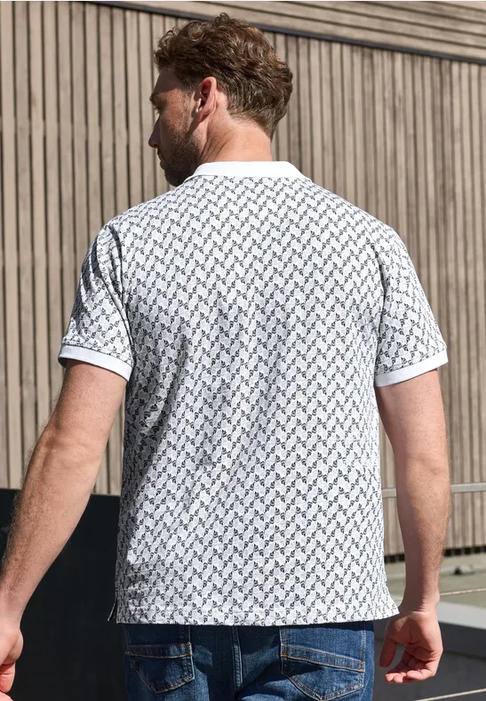 Mann in weißem Muster-T-Shirt von hinten vor Holzwand.
