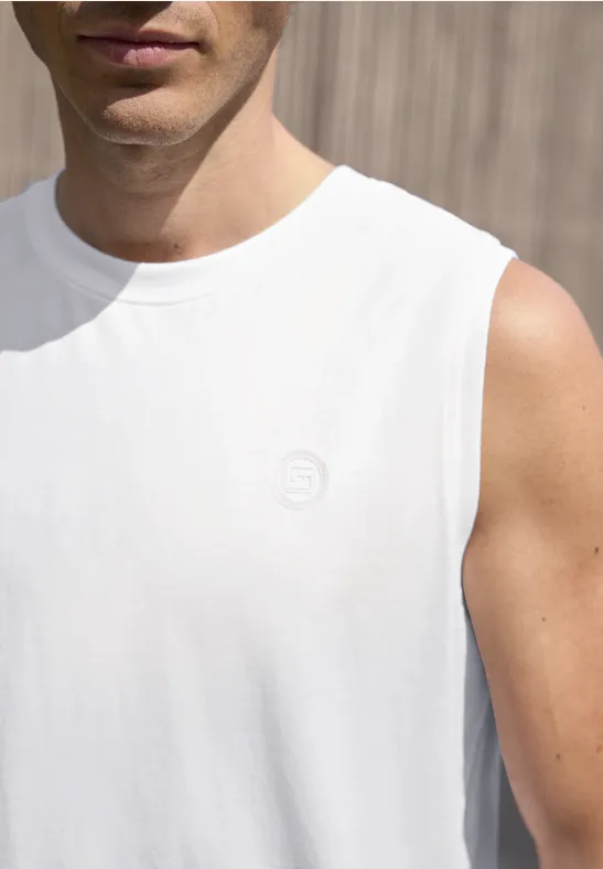 Close-up van een man met een wit mouwloos shirt voor een houten wand.
