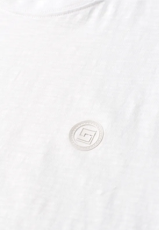 Weißes T-Shirt mit rundem, dezentem Logo in Salbeigrün auf der Brust.