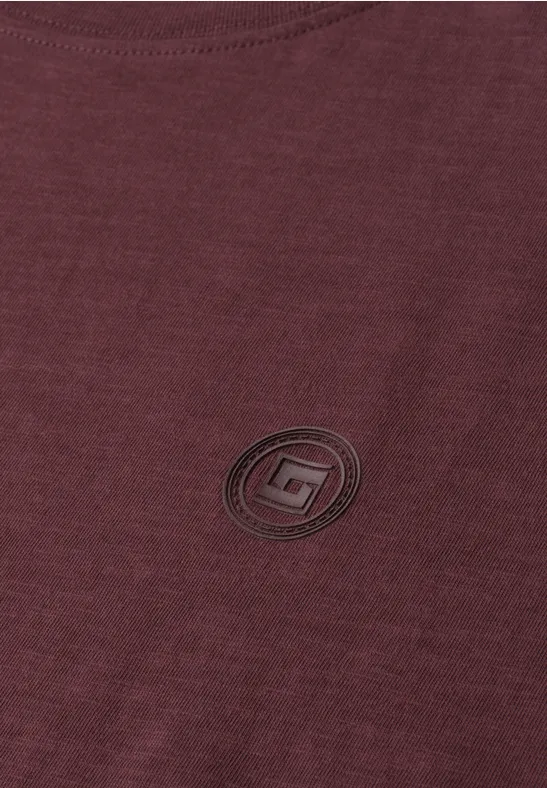 Bordeaux-farbenes T-Shirt mit rundem, schwarzem Logo auf der Brust