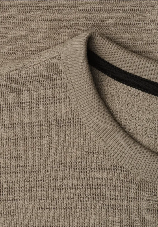 Nahaufnahme eines beigen Strickpullover-Ausschnitts mit rundem Kragen.