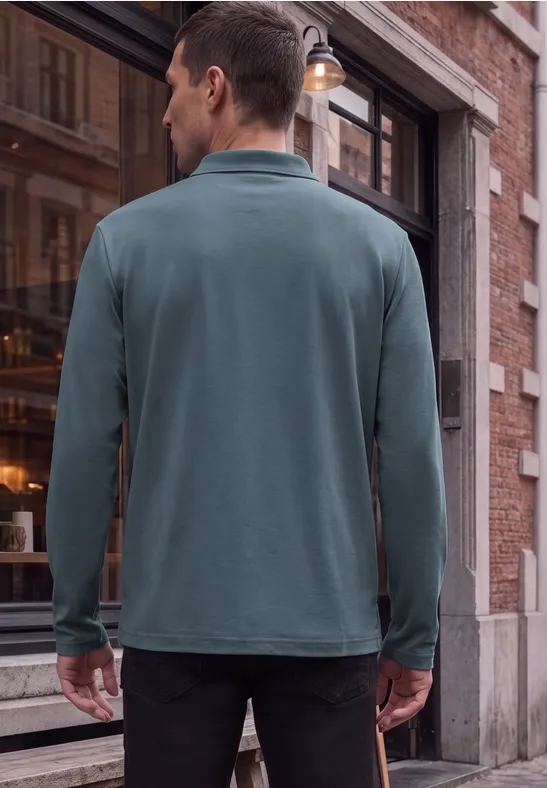 Ein Mann steht in einem grünen Langarm-Poloshirt vor der Schaufensterfront eines Cafés aus rotem Backstein.