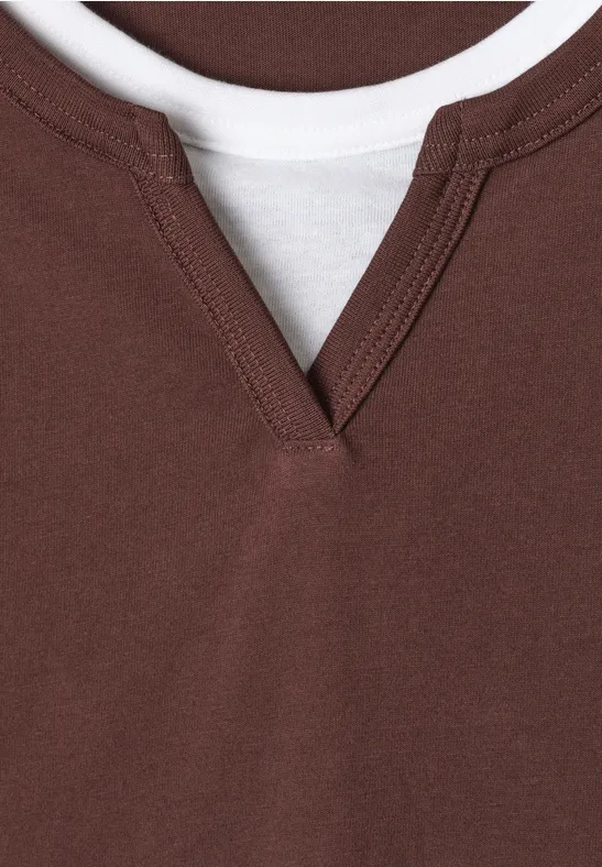 Nahaufnahme: Braunes V-Ausschnittshirt über weißem T-Shirt