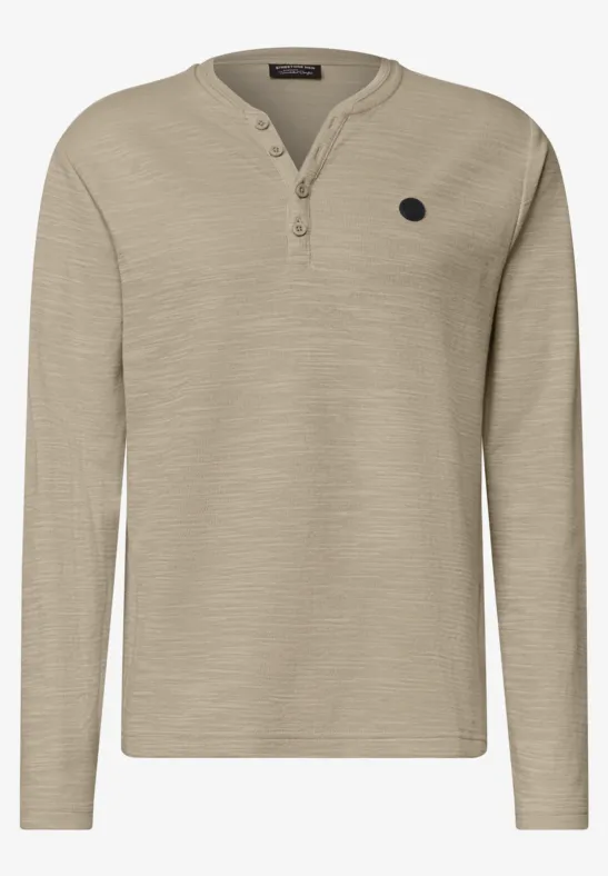 Beiges langärmliges Henley-Shirt mit Knopfleiste am Kragen und kleinem Logo-Patch auf der Brust.