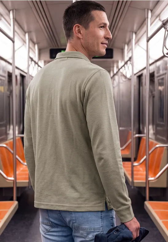 Un homme est debout dans le métro et regarde par-dessus son épaule vers l'appareil photo.