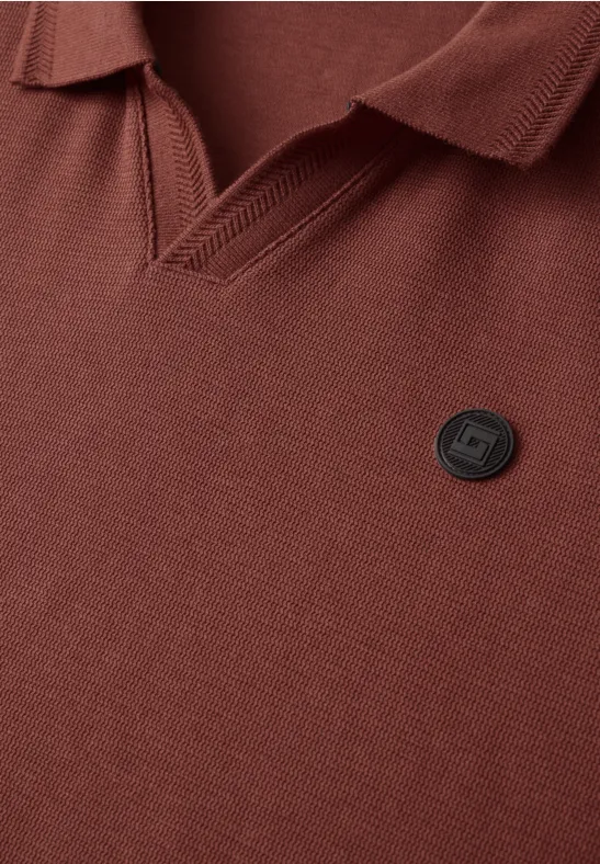 Braunes Poloshirt mit V-Kragen und kleinem runden Logo-Badge auf der Brust.