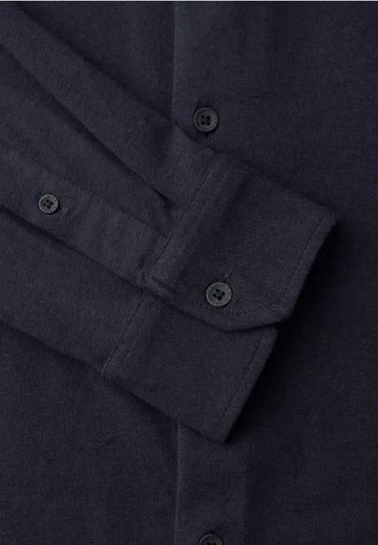 Nahaufnahme eines dunkelblauen Hemds mit Knopfleiste und Manschette.