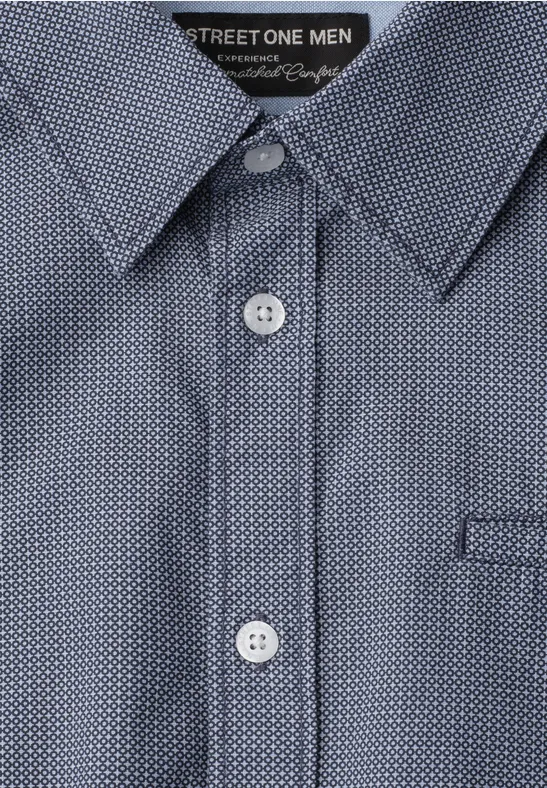 Hemd mit blauem Polka-Dot-Muster, weißen Knöpfen und spitzem Kragen.