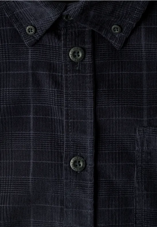 Gros plan d’une chemise sombre à carreaux avec boutons et poche poitrine