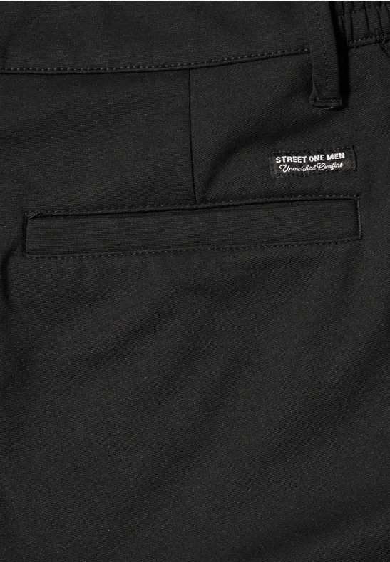 Nahaufnahme einer schwarzen Hose mit eingesetzter Gesäßtasche und kleinem weißen Label über der Tasche.