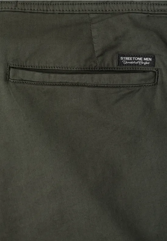 Detailansicht einer olivgrünen Hose mit Gesäßstasche und Stretch-Label.