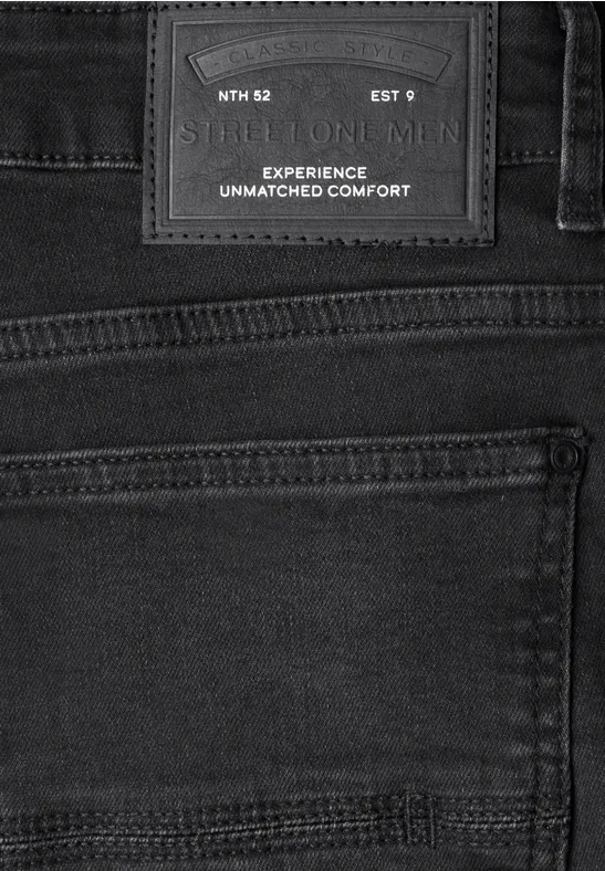 Schwarze Jeansrückansicht mit aufgesetzter Gesäßtasche und Lederpatch 'Experience Unmatched Comfort'.