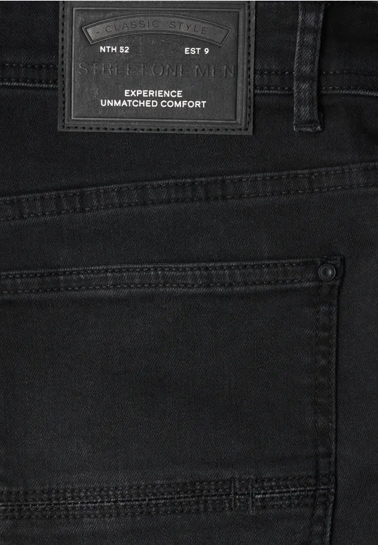 Zbliżenie czarnych jeansów z tylną kieszenią i naszywką 'Experience Unmatched Comfort'