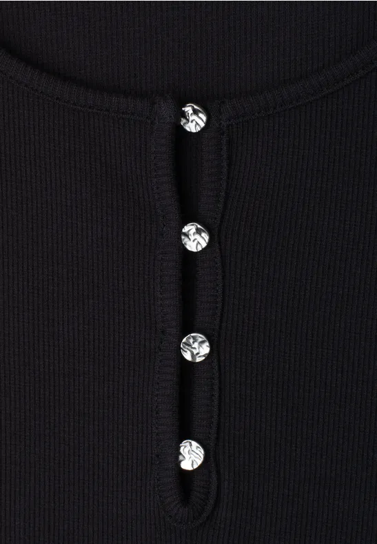 Zwarte, geribbelde top met glinsterende sierknopen.