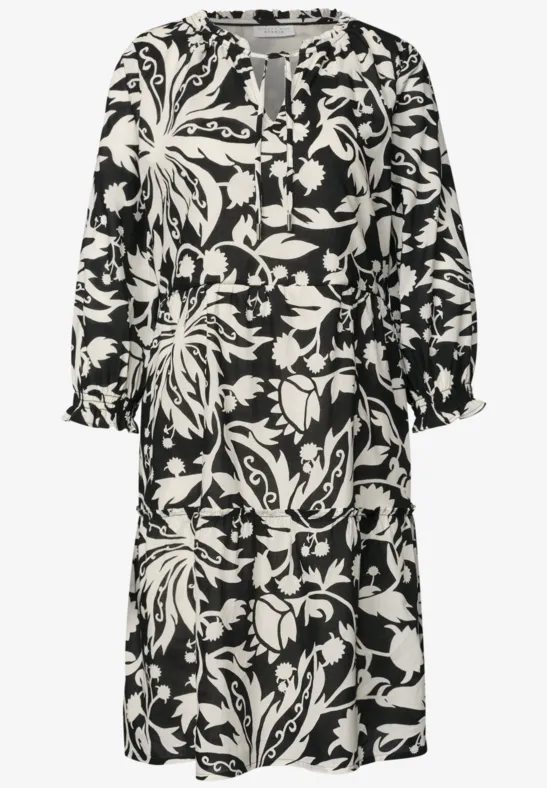 Schwarz-weißes Midikleid mit floralem Muster, langen Ärmeln und lockerem Schnitt.