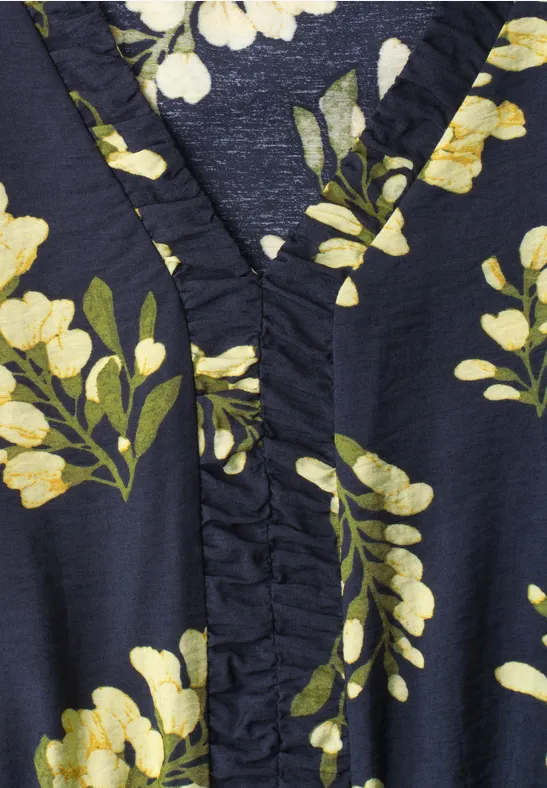 Detailaufnahme eines dunkelblauen Stoffs mit gelb-weißen Blumen und grünen Blättern