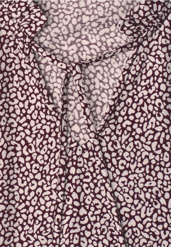 Braun-beige Blusenstoff mit Leopardenmuster, in der Bildmitte geknotet.