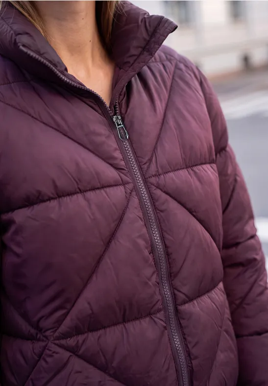 Close-up van persoon met een donkerpaars doorgestikte winterjas met ritssluiting.