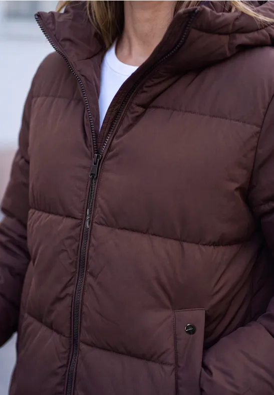 Eine Person trägt eine braune Steppjacke mit Reißverschluss und seitlichen Taschen.