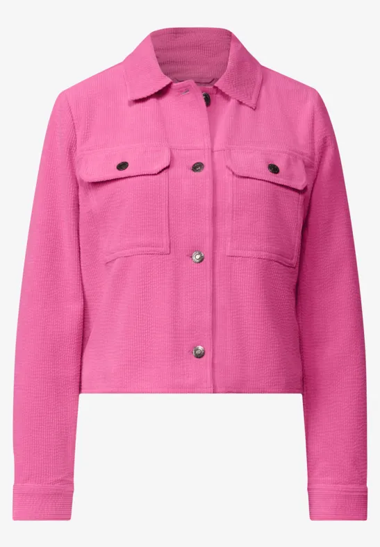 Kurz geschnittene, pinke Jeansjacke mit Knopfleiste und Brusttaschen.