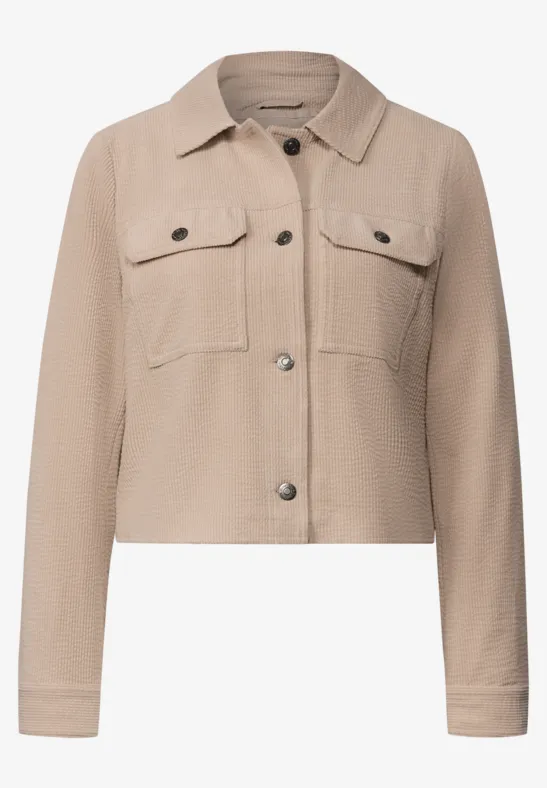 Beige kurze Jacke im Hemdfstil mit Brusttaschen und Metallknöpfen.
