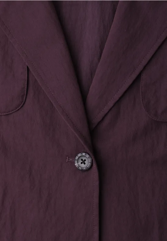 Nahaufnahme eines plumfarbenen Blazers mit Kragen und Knopf