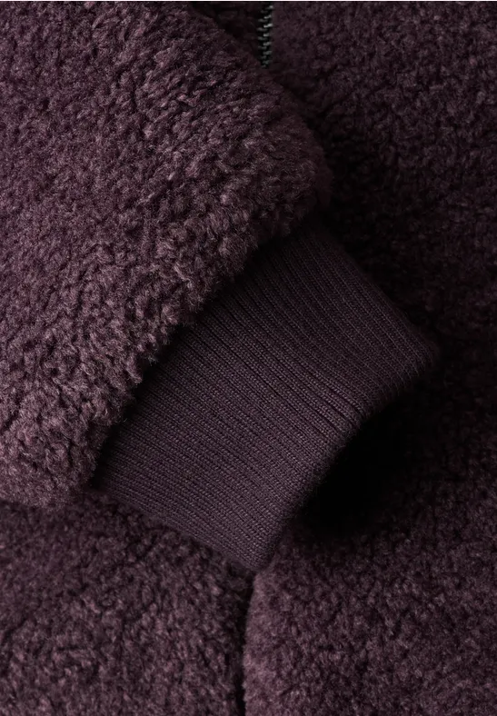 Nahaufnahme eines dunkellila Teddy-Fleece-Jackenärmels mit elastischer Bündchenmanschette.
