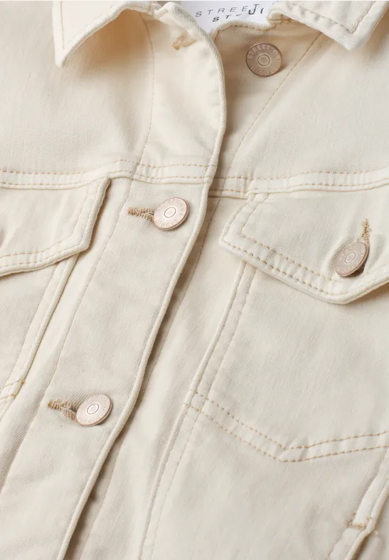 Nahaufnahme einer hellen Jeansjacke mit sichtbaren Taschen und Knöpfen.