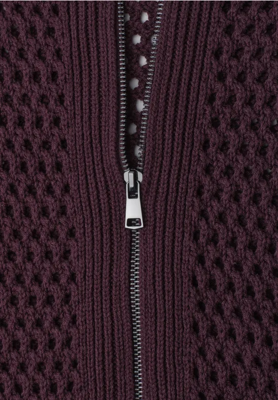 Nahaufnahme eines dunkelvioletten Strickstoffs mit einem silbernen Reißverschluss
