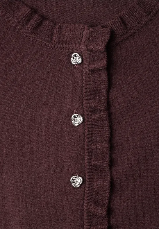 Dunkelroter Cardigan mit Rüschenrand und drei silbernen Herzknöpfen.