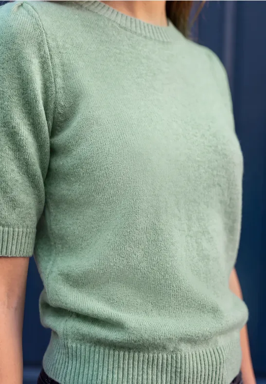 Close-up eines hellgrünen, kurzärmligen Strickpullovers.
