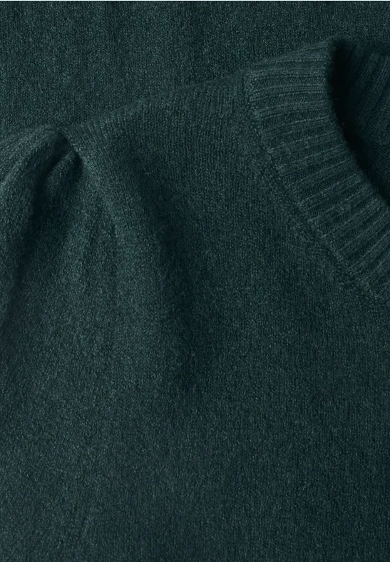 Dunkelgrüner Strickpullover mit Rundhalsausschnitt und leicht gerafftem Puffärmel in Nahaufnahme.