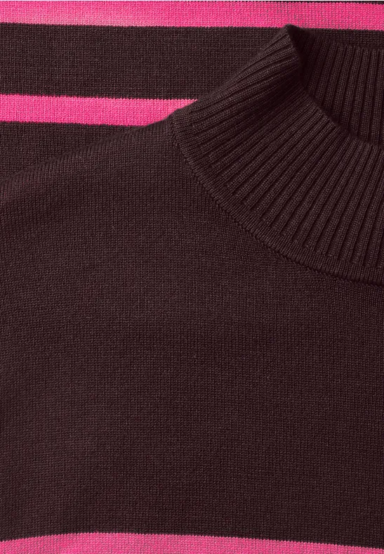 Gros plan d’un pull bordeaux à col roulé avec des bandes roses.
