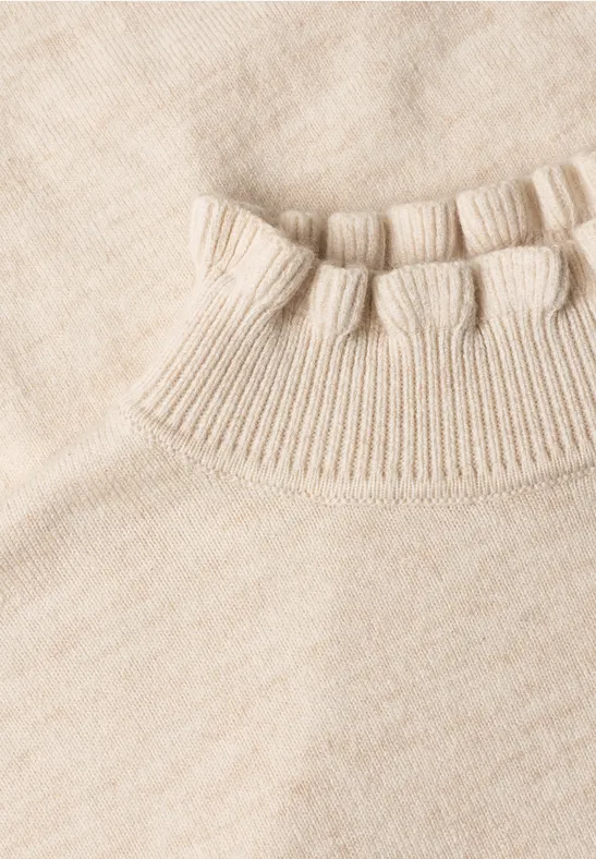 Nahaufnahme eines hellbeigen Strickpullovers mit Rippkragen