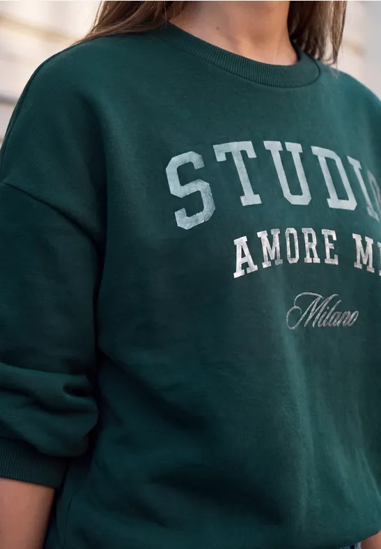 Butelkowozielony sweter z białym napisem 'STUDIA AMORE Milano'.