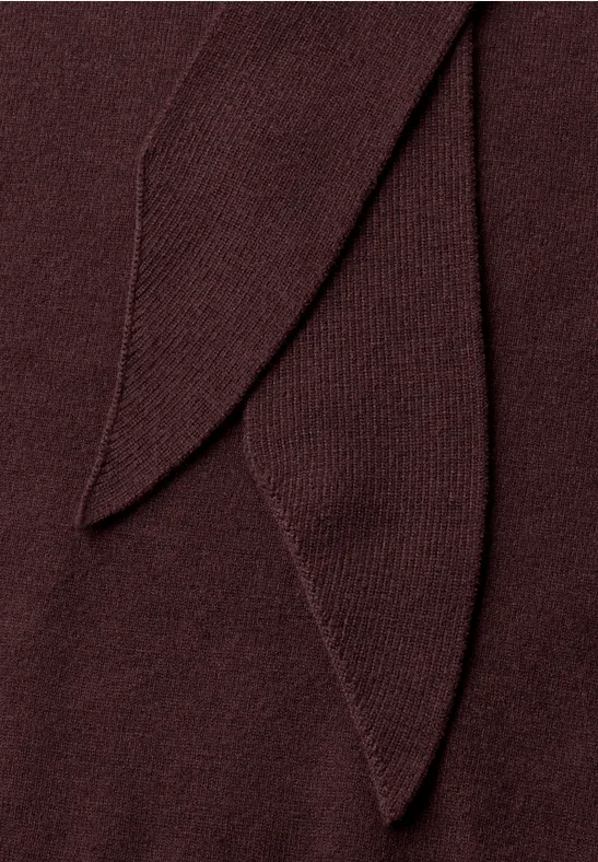 Nahaufnahme eines dunkelroten, gestrickten Stoffes mit überlappenden Laschen.