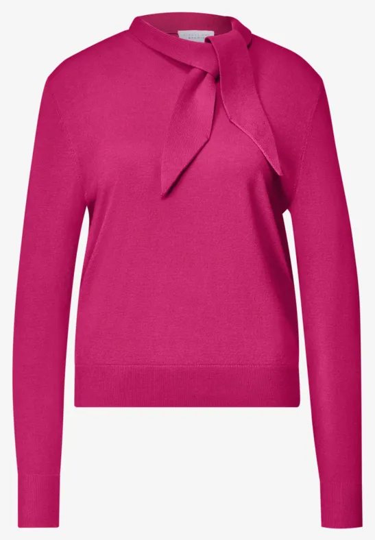 Fuchsiafarbener Damenpullover mit langen Ärmeln und seitlich gebundener Schleife am Stehkragen.