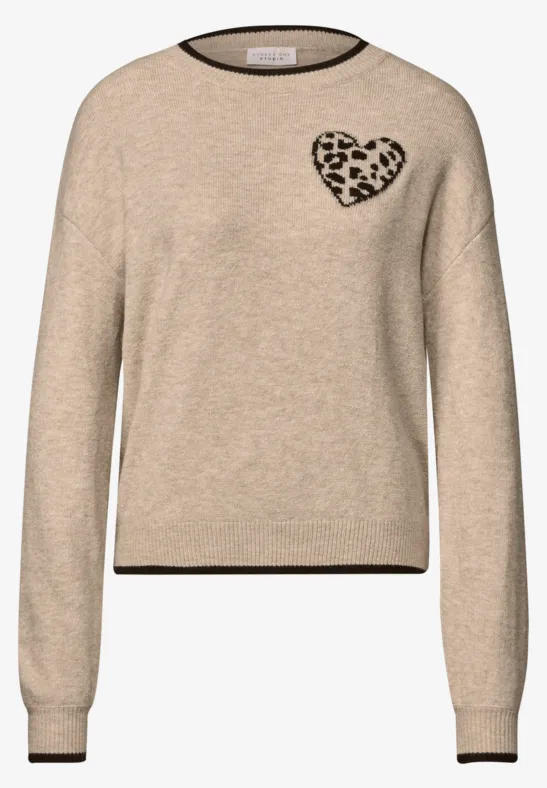 Beiger Pullover mit schwarzer Einfassung und einem Leopardenherz auf der Brust.