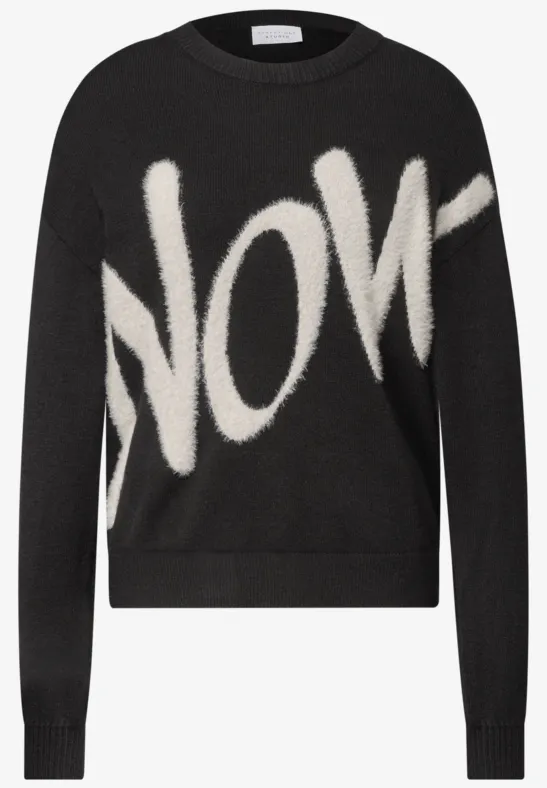 Schwarzer Pullover mit weißem, flauschigem Schriftzug 'NOW'.