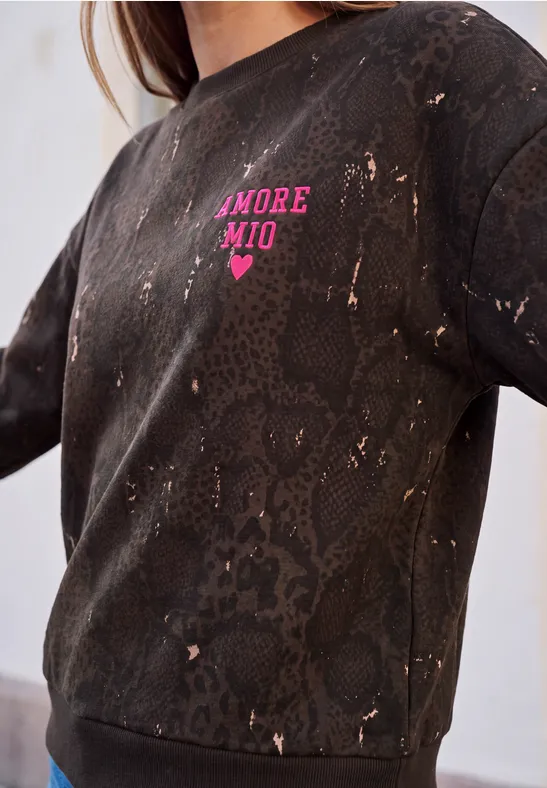 Dunkles Sweatshirt mit Schlangenhautmuster und 'AMORE MIO'-Aufdruck in Pink und Herzmotiv.